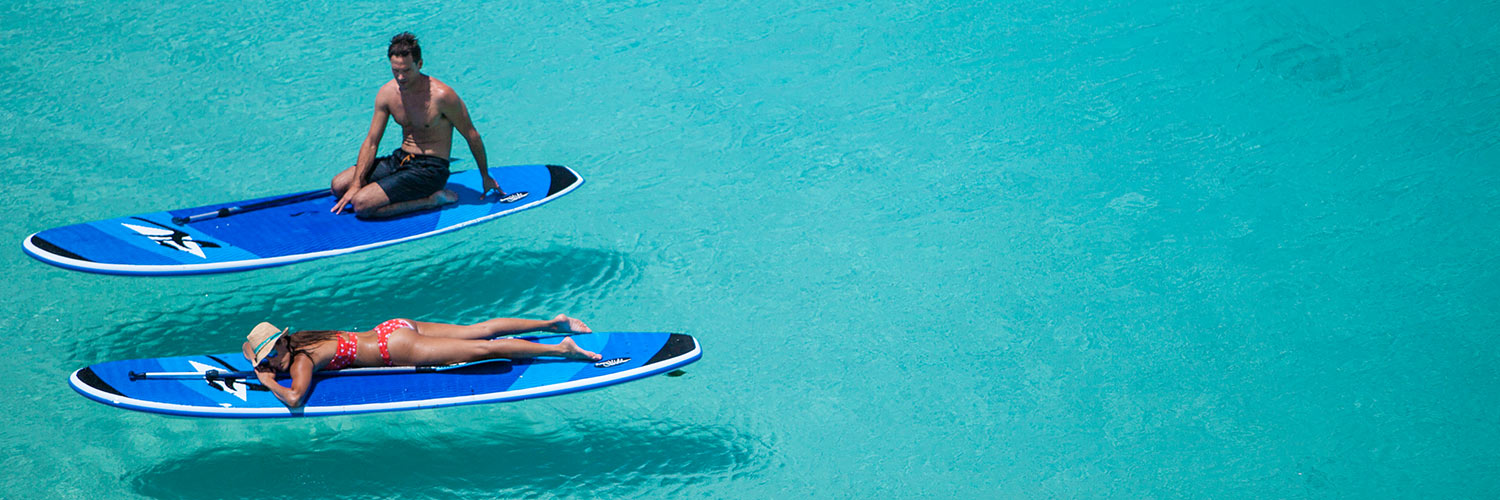 Guest relaxing on paddle boards on Anchor Bay, Lizard Island
