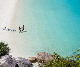Couple walking on the beach on Lizard Island
